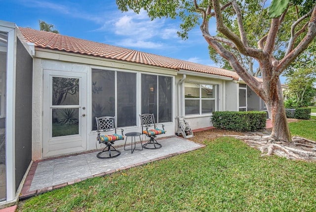 rear view of house featuring a yard and a patio