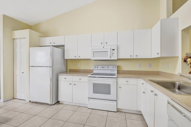 kitchen featuring white cabinetry, sink, light tile patterned floors, and white appliances