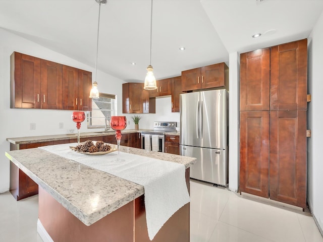 kitchen with a kitchen bar, appliances with stainless steel finishes, light tile patterned floors, pendant lighting, and a center island