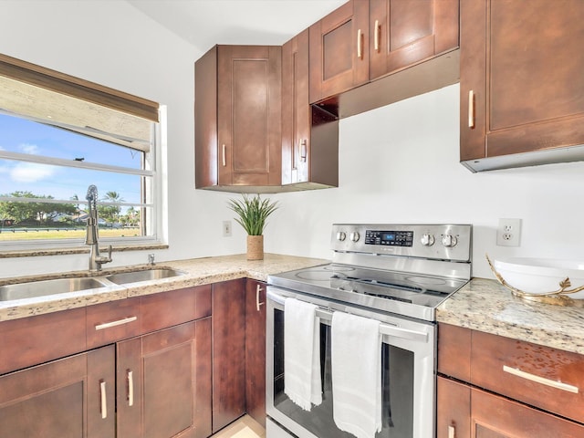 kitchen featuring stainless steel electric range, light stone counters, and sink