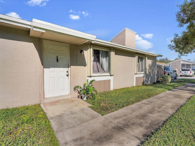 property entrance with a yard