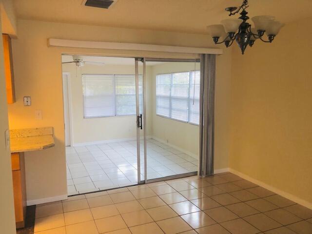 unfurnished bedroom featuring tile patterned flooring and a chandelier