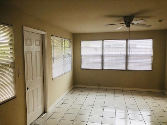 unfurnished sunroom with ceiling fan