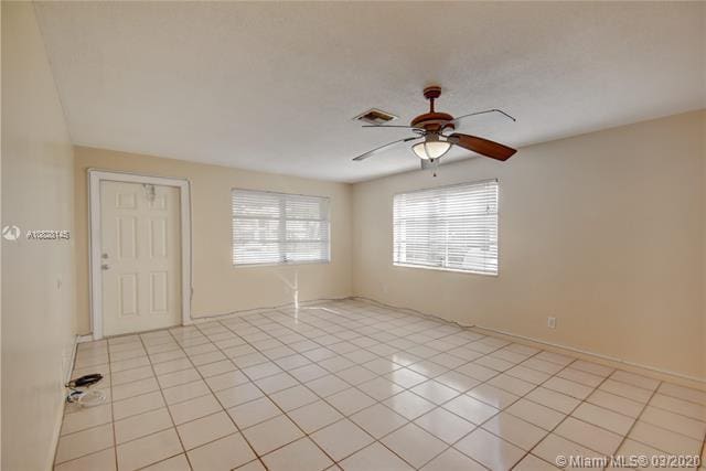 unfurnished room featuring light tile patterned floors and ceiling fan