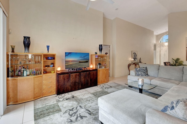 living room with ceiling fan, light tile patterned flooring, and high vaulted ceiling