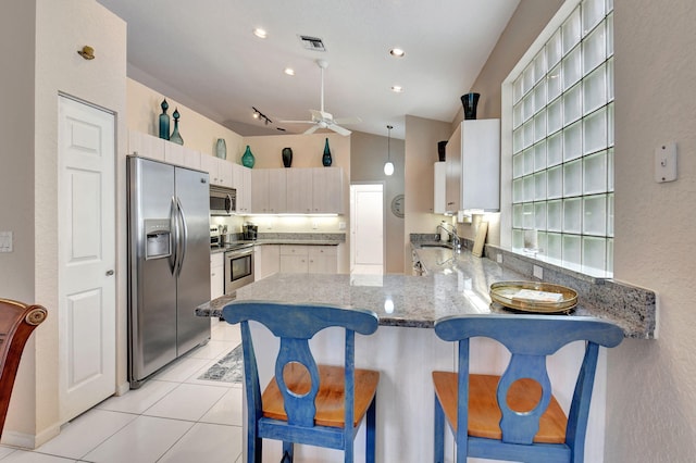 kitchen featuring pendant lighting, lofted ceiling, ceiling fan, appliances with stainless steel finishes, and kitchen peninsula