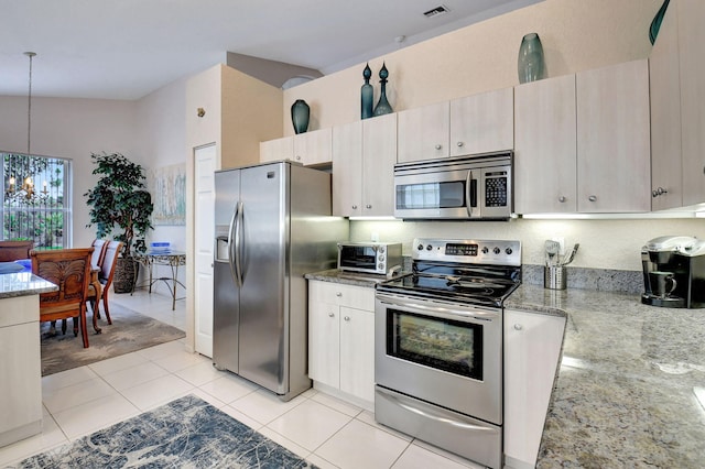 kitchen with stainless steel appliances, vaulted ceiling, decorative light fixtures, stone counters, and a chandelier