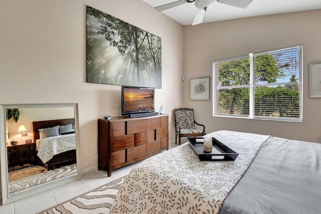 bedroom featuring ceiling fan, light tile patterned flooring, and lofted ceiling