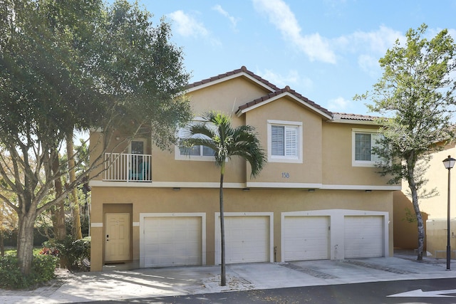 view of front of home featuring a garage, a tiled roof, and stucco siding