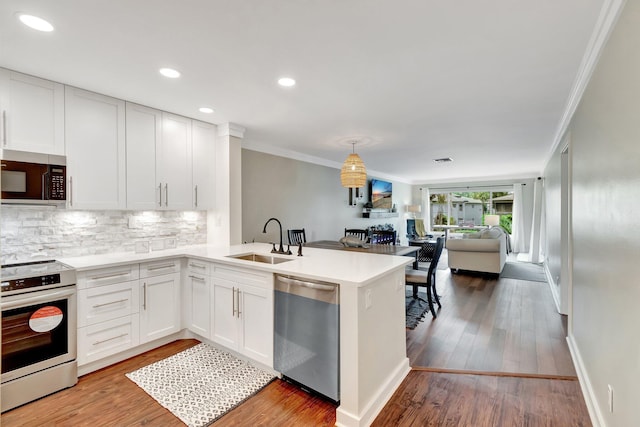 5770 Princess Palm Ct Unit F, Delray Beach, FL 33484 - kitchen with stainless steel appliances, open floor plan, backsplash, crown molding, and white cabinetry