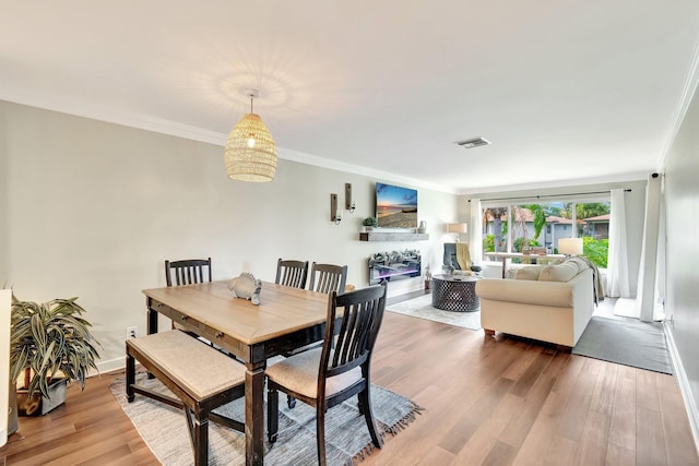 5770 Princess Palm Ct Unit F, Delray Beach, FL 33484 - dining area with wood finished floors, ornamental molding, and a glass covered fireplace