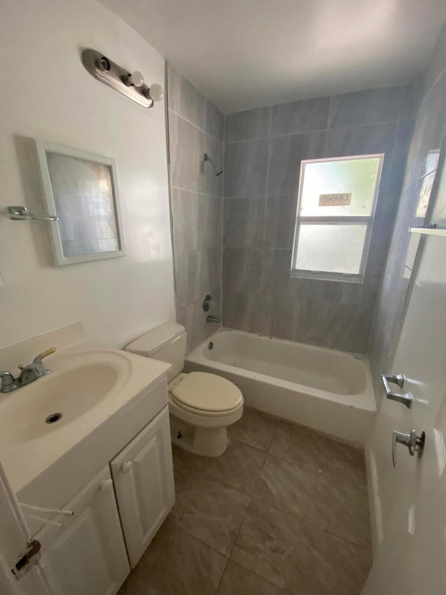 full bathroom featuring tile patterned floors, vanity, toilet, and tiled shower / bath combo