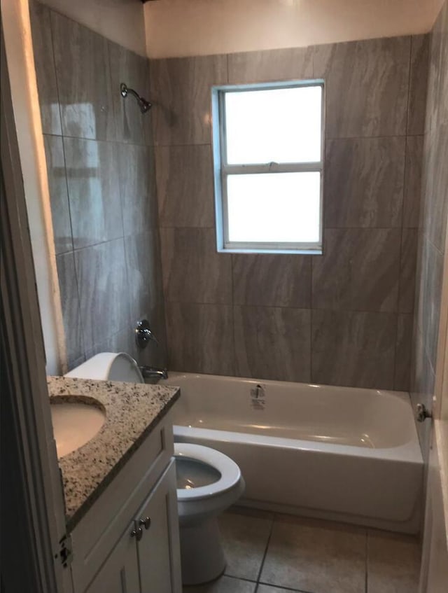 full bathroom with tiled shower / bath, vanity, toilet, and tile patterned flooring