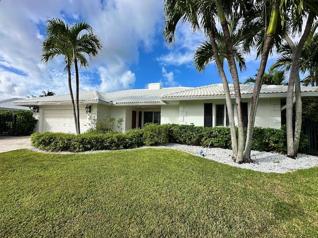 single story home with a garage and a front lawn