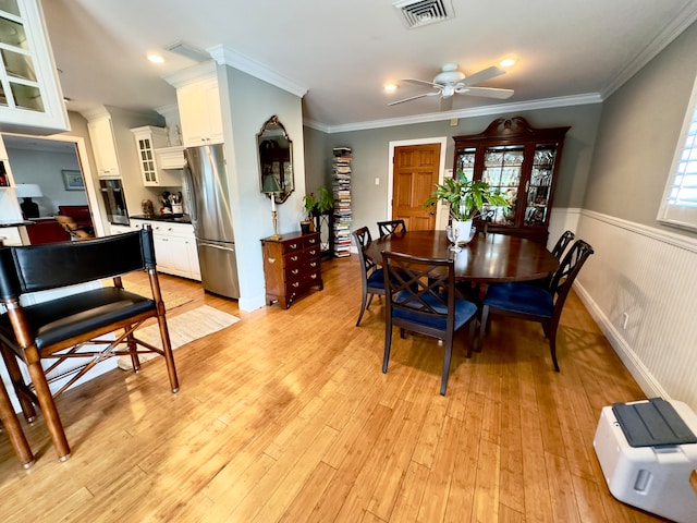 dining space featuring ceiling fan, light hardwood / wood-style floors, and ornamental molding