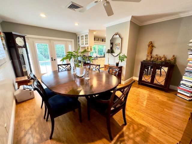 dining space with french doors, light wood-type flooring, ceiling fan, and crown molding