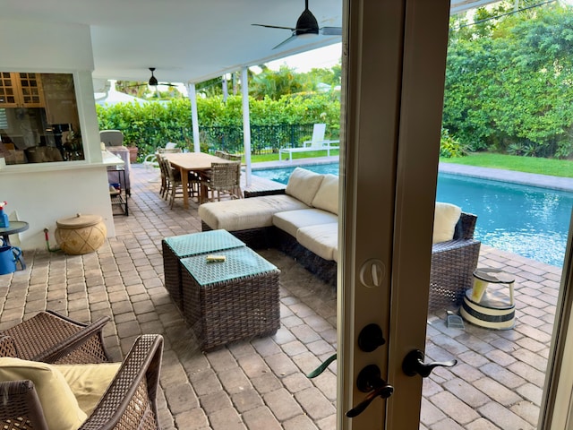 view of patio featuring a fenced in pool, outdoor lounge area, and ceiling fan