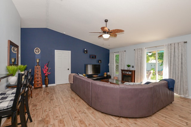 living room featuring light hardwood / wood-style floors, vaulted ceiling, and ceiling fan