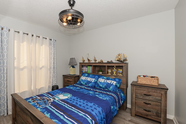 bedroom with hardwood / wood-style floors and a textured ceiling