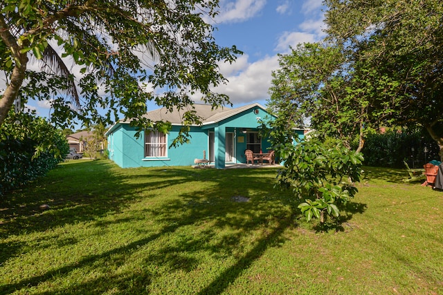 rear view of property featuring a lawn