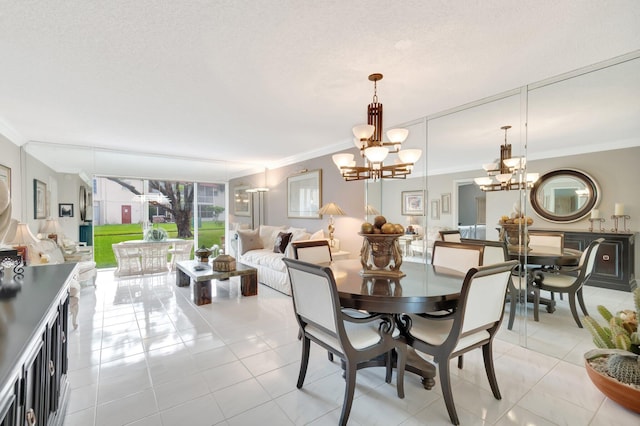 tiled dining area featuring ornamental molding, a textured ceiling, and an inviting chandelier