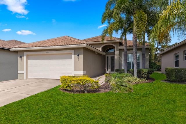 mediterranean / spanish-style house with a garage and a front lawn