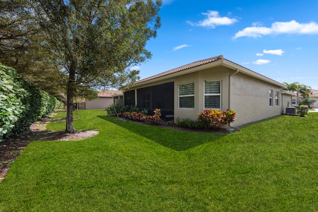 view of home's exterior with central AC unit, a sunroom, and a yard