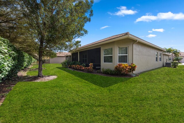 8313 Boulder Mountain Ter, Boynton Beach, FL 33473 - view of home's exterior with a yard, stucco siding, central air condition unit, and a sunroom