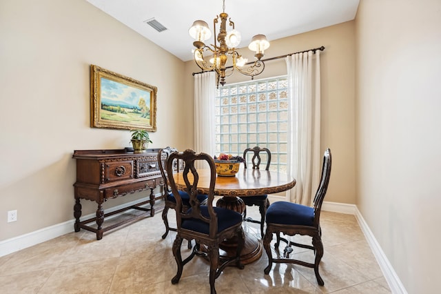 tiled dining room with a chandelier