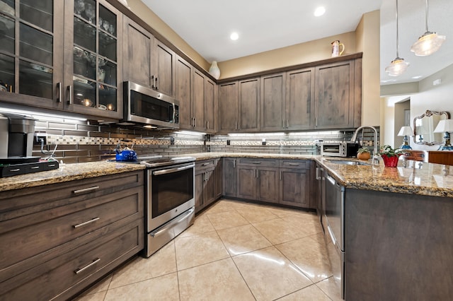 kitchen with tasteful backsplash, hanging light fixtures, dark brown cabinets, and stainless steel appliances