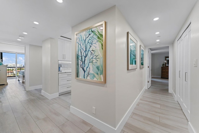 hallway with light hardwood / wood-style floors