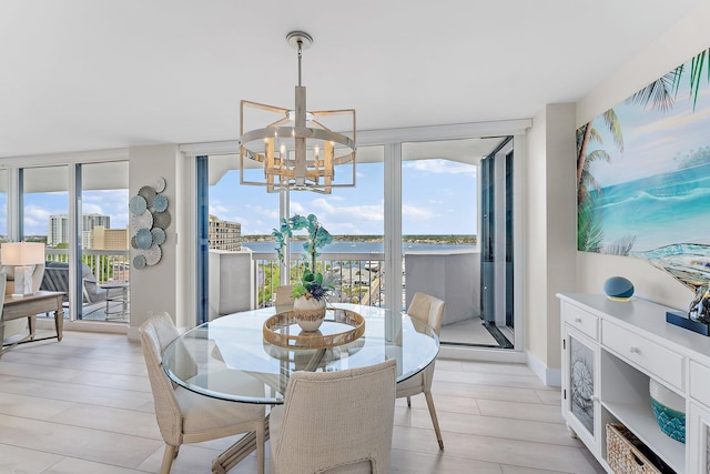 dining space featuring expansive windows, light hardwood / wood-style floors, and an inviting chandelier