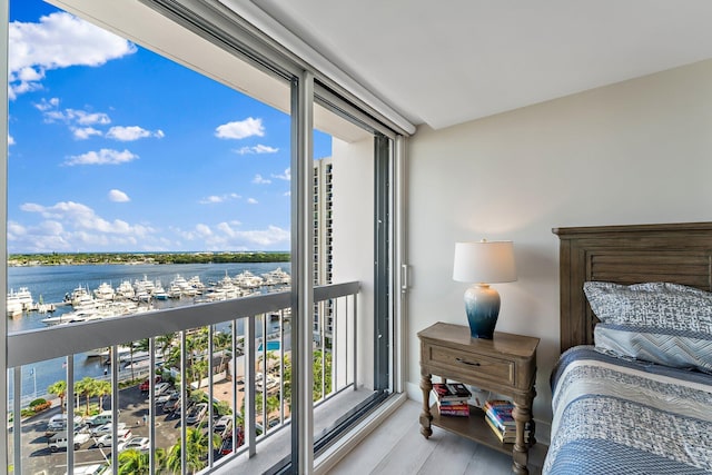 bedroom featuring a water view and light hardwood / wood-style floors