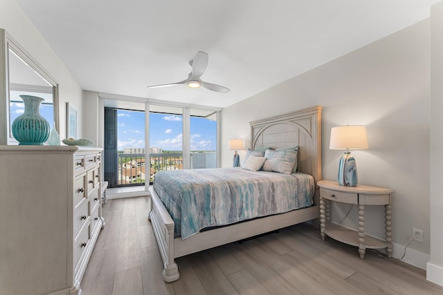 bedroom featuring ceiling fan, access to exterior, light hardwood / wood-style flooring, and multiple windows