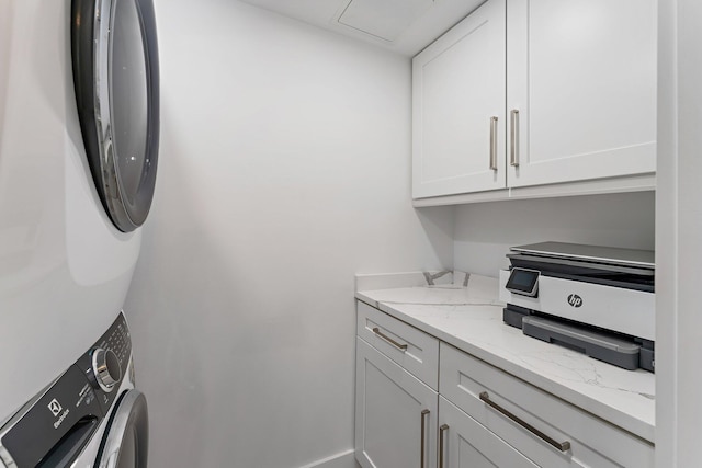 clothes washing area featuring stacked washer and clothes dryer