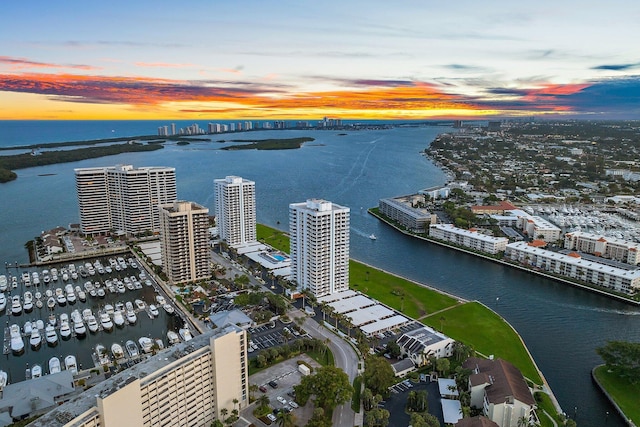 aerial view at dusk featuring a water view