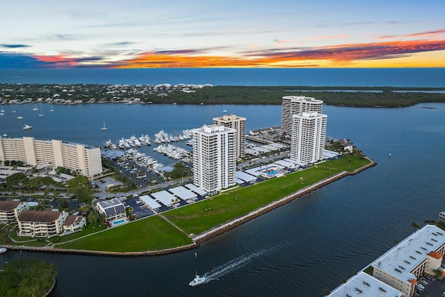 aerial view at dusk featuring a water view