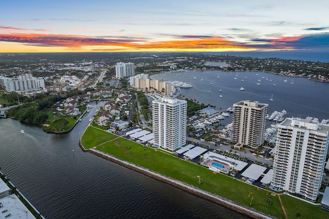 aerial view at dusk featuring a water view