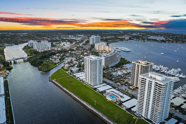 aerial view at dusk featuring a water view