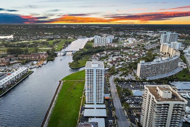 aerial view at dusk featuring a water view