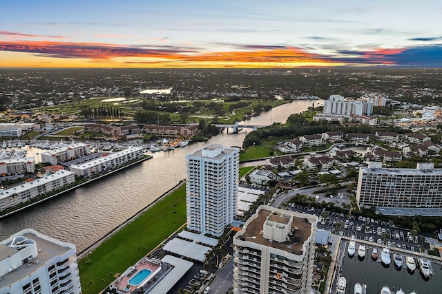 aerial view at dusk featuring a water view