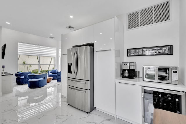 kitchen featuring white cabinets, stainless steel fridge with ice dispenser, and wine cooler