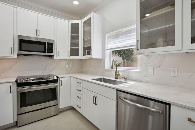 kitchen with sink, appliances with stainless steel finishes, decorative backsplash, white cabinets, and ornamental molding