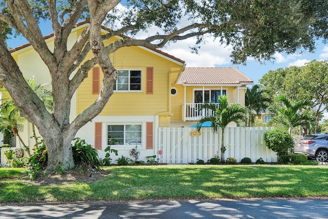 view of front facade with a front yard and a balcony