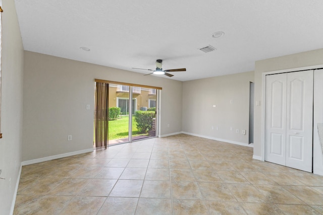 spare room with ceiling fan and light tile patterned floors