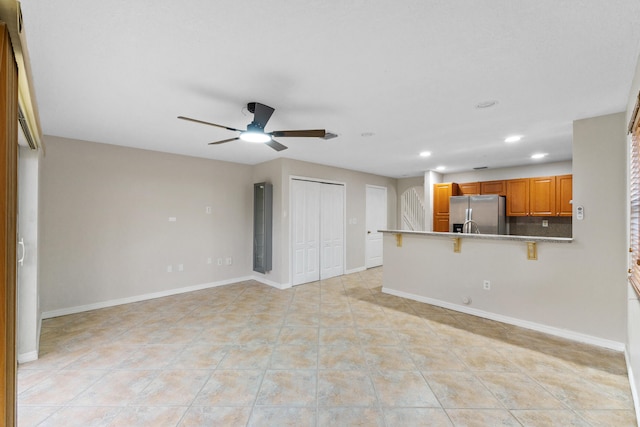 unfurnished living room featuring ceiling fan and light tile patterned floors