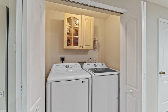 washroom featuring cabinets and washer and dryer