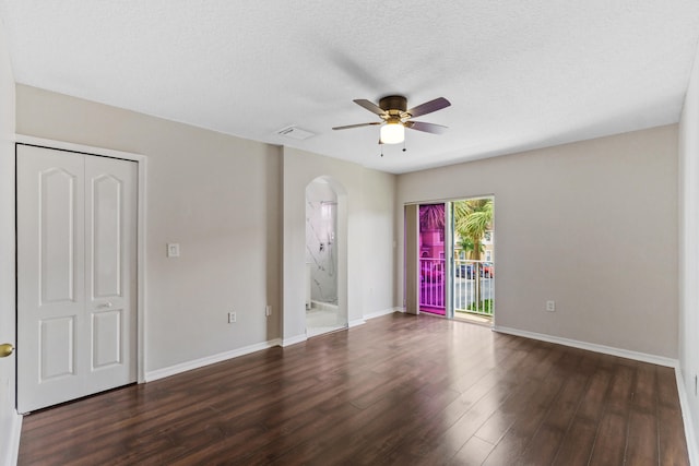 empty room with dark hardwood / wood-style floors, ceiling fan, and a textured ceiling