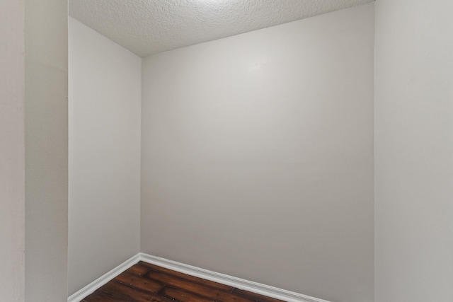 spare room with dark wood-type flooring and a textured ceiling