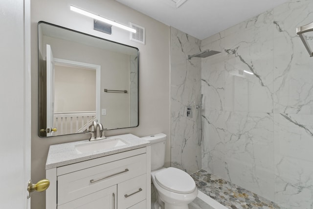 bathroom featuring vanity, toilet, and tiled shower